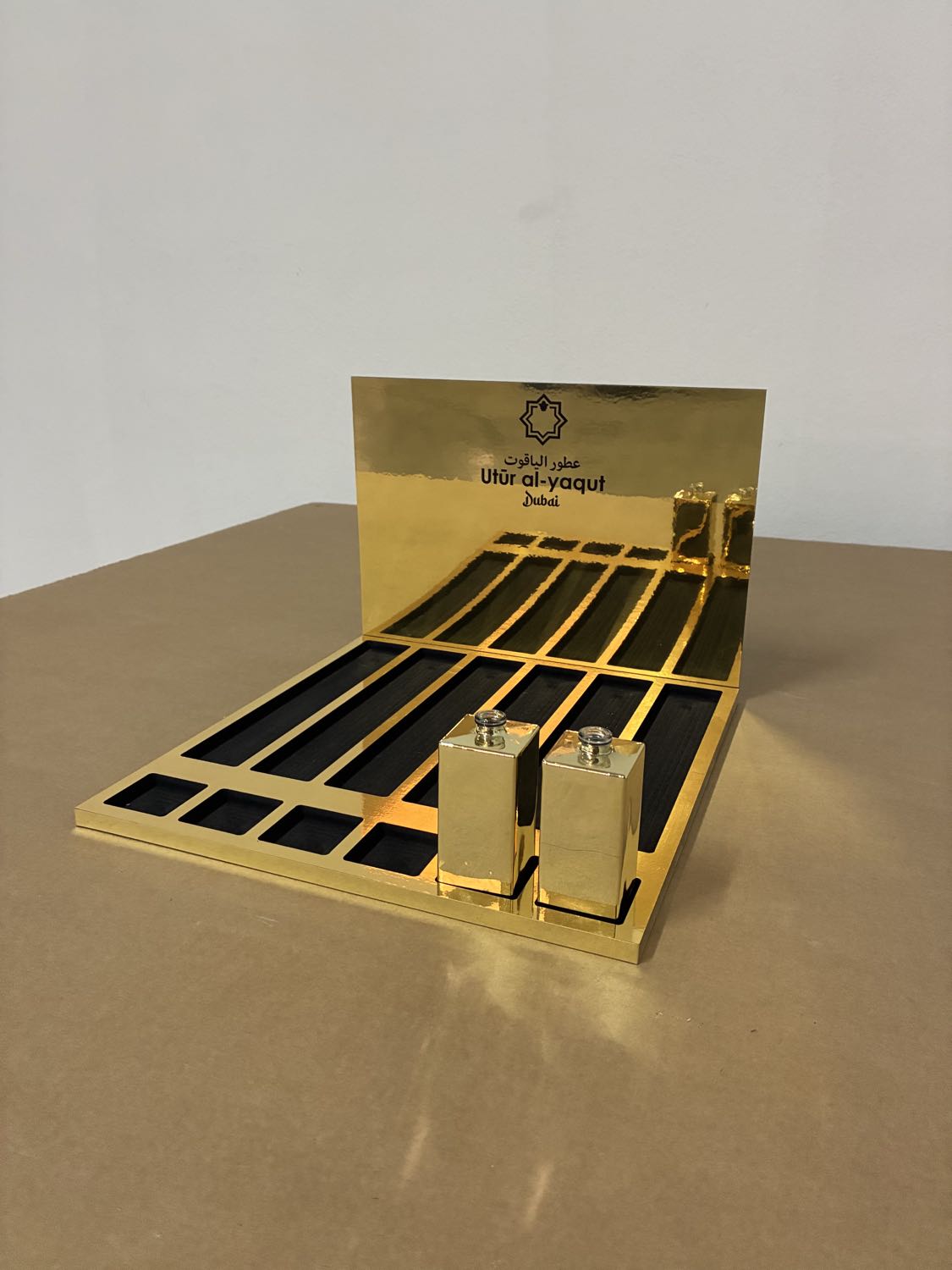 Glorificador dorado con acabado espejo de Utur al-Yaqut con los frascos de perfume colocados