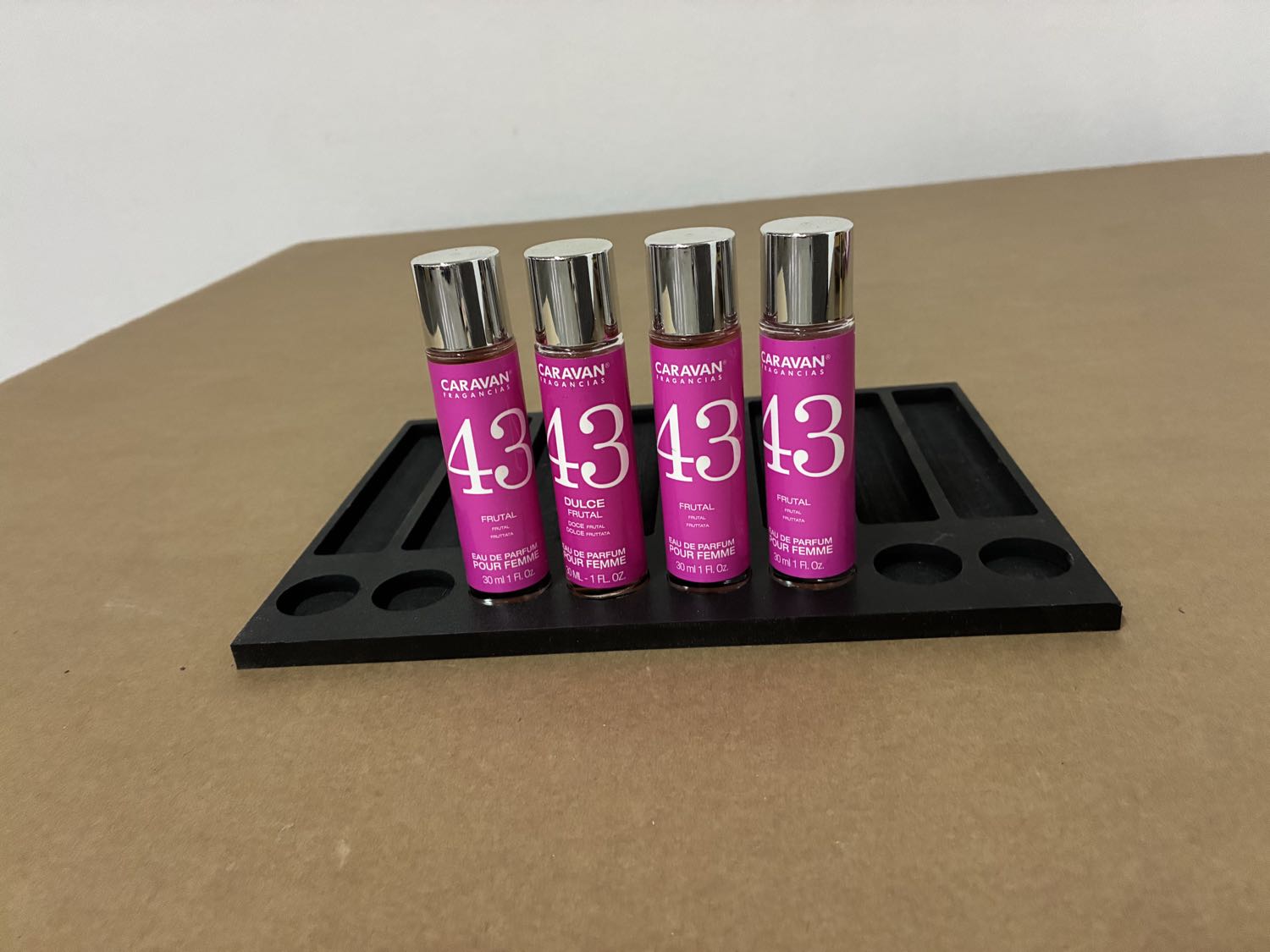 Glorificador negro de PVC para perfumería con testers de fragancia colocados